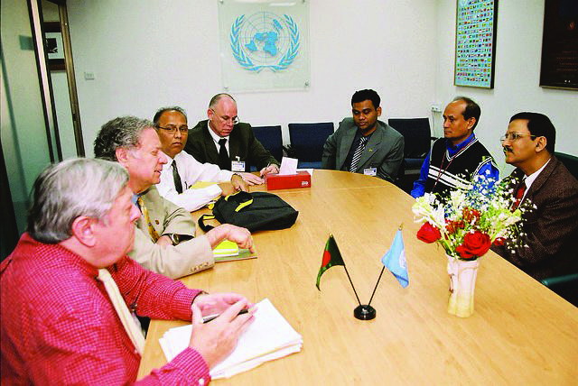 Delegates seated around a conference table beneath the United Nations emblem